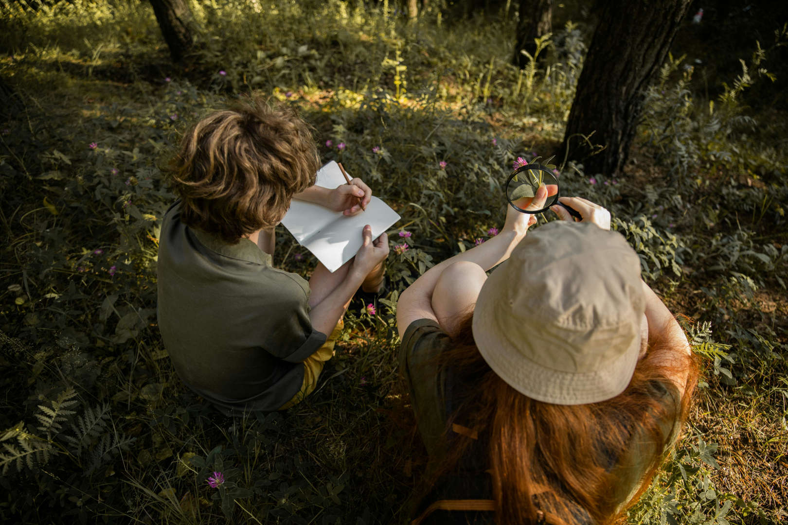 Schreibende Kinder auf dem Waldboden.
